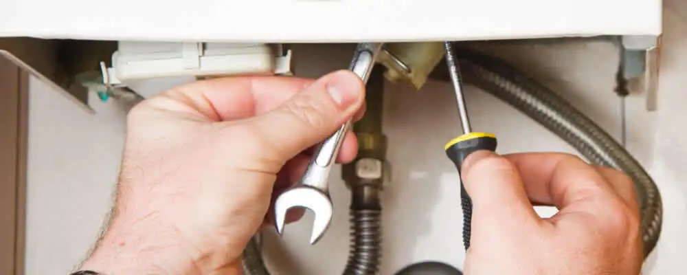 Boiler repair technician tightening pipe fittings and connections in Peoria, IL