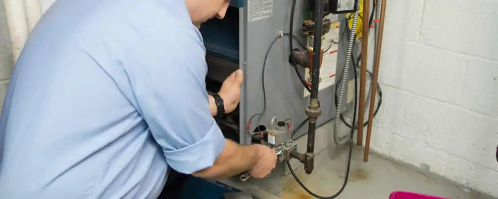 Furnace repair technician inspecting and servicing a home heating system in Peoria, IL