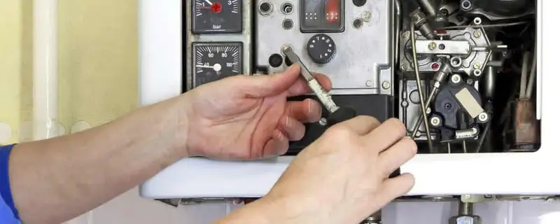 Heating repair technician adjusting boiler controls and components in Peoria, IL