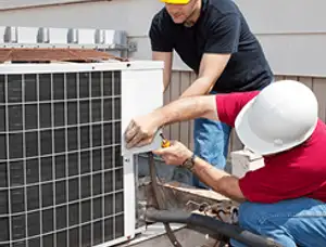 HVAC technicians repairing an outdoor AC unit on a rooftop in Peoria, IL