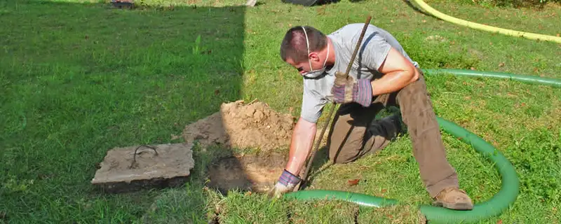 Septic pumping technician servicing a residential septic tank in Peoria, IL